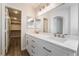 Bathroom featuring double sinks, large mirror, and access to the walk-in closet at 844 Binbrook Dr, Henderson, NV 89052