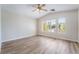 Bright, spacious bedroom with wood-look floors, a ceiling fan, and three sunny windows at 844 Binbrook Dr, Henderson, NV 89052