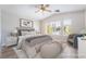 Staged bedroom featuring a bed, seating area, and ample natural light from windows at 844 Binbrook Dr, Henderson, NV 89052