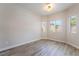 Empty bedroom with vinyl floors, bright neutral paint and trim and three large windows at 844 Binbrook Dr, Henderson, NV 89052