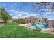Aerial view of a backyard featuring a pool with rock features, mature trees, and lush greenery at 8945 S Tenaya Way, Las Vegas, NV 89113