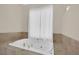 Close-up shot of a luxurious soaking tub featuring elegant fixtures and natural stone tile surround at 8945 S Tenaya Way, Las Vegas, NV 89113