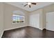 Bedroom with hardwood floors, closet, ceiling fan, and a view of the neighborhood at 8945 S Tenaya Way, Las Vegas, NV 89113
