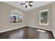 Bedroom with hardwood floors, ceiling fan, natural light, and a view of the neighborhood at 8945 S Tenaya Way, Las Vegas, NV 89113