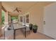 Relaxing covered patio with ceiling fan, dining table, and views of the beautiful backyard at 8945 S Tenaya Way, Las Vegas, NV 89113