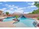 Beautiful backyard pool with a natural rock waterfall feature, lush landscaping, and serene environment at 8945 S Tenaya Way, Las Vegas, NV 89113