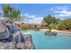 Backyard pool with a stunning stone waterfall feature, beautiful landscaping, and a tranquil setting at 8945 S Tenaya Way, Las Vegas, NV 89113