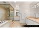 Luxurious primary bathroom featuring double sinks, a soaking tub, and a separate glass-enclosed shower at 9101 Alta Dr # 706, Las Vegas, NV 89145