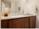 Bathroom vanity with a neutral countertop and dark wood cabinetry below sink at 9373 Oxbow Lake Ave, Las Vegas, NV 89149
