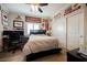 Automotive themed bedroom featuring a large bed, ceiling fan, and walls covered in racing memorabilia at 9373 Oxbow Lake Ave, Las Vegas, NV 89149