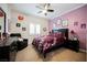 Cozy bedroom with carpet, ceiling fan, and framed prints adorning the purple accent wall at 9373 Oxbow Lake Ave, Las Vegas, NV 89149