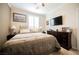 Serene bedroom with neutral tones, comfortable bed, and a dark wood dresser beneath a mounted television at 9373 Oxbow Lake Ave, Las Vegas, NV 89149