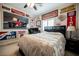 Automotive themed bedroom featuring a large bed, ceiling fan, and walls covered in racing memorabilia at 9373 Oxbow Lake Ave, Las Vegas, NV 89149