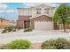 Welcoming two-story home with brick accents, a two-car garage, and beautiful landscaping at 9373 Oxbow Lake Ave, Las Vegas, NV 89149