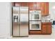 Gourmet kitchen featuring stainless steel refrigerator, double ovens, and dark wood cabinetry at 9373 Oxbow Lake Ave, Las Vegas, NV 89149