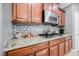 Close-up of the kitchen, featuring granite countertops, stainless steel appliances, and wood cabinets at 9373 Oxbow Lake Ave, Las Vegas, NV 89149