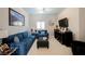 Cozy living room with comfortable blue furniture, a TV, and natural light from a window at 9373 Oxbow Lake Ave, Las Vegas, NV 89149