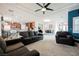 Spacious living room features a ceiling fan, plush carpet, and flows into the open kitchen and dining area at 9373 Oxbow Lake Ave, Las Vegas, NV 89149