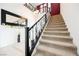 Carpeted staircase featuring decorative wrought iron railings and a chandelier at 9373 Oxbow Lake Ave, Las Vegas, NV 89149