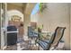 Cozy backyard patio with brick pavers, stucco walls, a grill, outdoor furniture and lush greenery at 939 Paisley St, Las Vegas, NV 89145