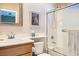 Bright bathroom featuring shower-tub combo, framed mirror and a single sink vanity with oak cabinets at 939 Paisley St, Las Vegas, NV 89145