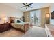 Comfortable bedroom with French doors to balcony, neutral carpet, and ceiling fan at 939 Paisley St, Las Vegas, NV 89145