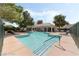 Community pool featuring lounge chairs, a shaded area with tables and chairs, and well-maintained landscaping at 939 Paisley St, Las Vegas, NV 89145