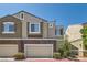 Lovely townhome with a two-car garage, brick accents, neutral stucco exterior, and simple landscaping for curb appeal at 939 Paisley St, Las Vegas, NV 89145