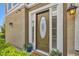 Close-up view of an inviting front door with a decorative oval window, sidelights and potted plants at 939 Paisley St, Las Vegas, NV 89145