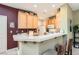 Warm kitchen featuring honey cabinets, white tile countertops, and a breakfast bar with seating at 939 Paisley St, Las Vegas, NV 89145
