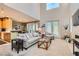 Open-concept living room features a fireplace, large windows, high ceilings and comfortable seating arrangement at 939 Paisley St, Las Vegas, NV 89145