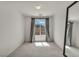 Bright bedroom featuring a large window with neutral curtains and a full length mirror at 9504 Empire Rock St, Las Vegas, NV 89143