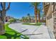 Beautiful front yard showcasing palm trees, green lawns, and a wide driveway at 9504 Empire Rock St, Las Vegas, NV 89143
