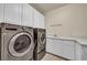 Functional laundry room showcasing modern washer and dryer units and ample cabinet space at 9504 Empire Rock St, Las Vegas, NV 89143