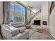 Open-concept living room with high ceilings, fireplace, and staircase at 9504 Empire Rock St, Las Vegas, NV 89143