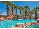 Resort style pool with stunning rock waterfall feature and mature palms at 9504 Empire Rock St, Las Vegas, NV 89143