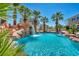 Resort-style pool with waterfall feature surrounded by palm trees providing a relaxing backyard oasis at 9504 Empire Rock St, Las Vegas, NV 89143