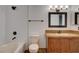 Bathroom featuring a classic vanity, decorative mirror, and tub-shower combination at 9655 Lame Horse Dr, Las Vegas, NV 89123
