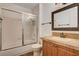 Bright bathroom with a shower-tub combo and decorative vanity with dark wood cabinets and tile countertop at 9655 Lame Horse Dr, Las Vegas, NV 89123