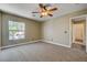 This bedroom provides natural light, carpet and an en suite bath at 9655 Lame Horse Dr, Las Vegas, NV 89123