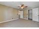 Neutral bedroom with plush carpet, ceiling fan, closet and door to the bathroom at 9655 Lame Horse Dr, Las Vegas, NV 89123