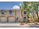 Two-story townhouse featuring attached garages, neutral stucco, and landscaped front yard at 9655 Lame Horse Dr, Las Vegas, NV 89123