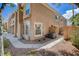 Exterior view of a two-story townhouse showcasing stucco facade, arched windows, and well-maintained landscaping at 9655 Lame Horse Dr, Las Vegas, NV 89123