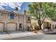 Exterior of a two-story townhouse with a well-maintained lawn, stucco siding, and tile roof at 9655 Lame Horse Dr, Las Vegas, NV 89123