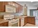 Kitchen featuring wood cabinets, white appliances, and tile countertops at 9655 Lame Horse Dr, Las Vegas, NV 89123
