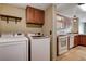Laundry room with appliances next to kitchen featuring wood cabinets and tile flooring at 9655 Lame Horse Dr, Las Vegas, NV 89123