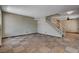 Open living room with staircase, tile flooring, and neutral color palette at 9655 Lame Horse Dr, Las Vegas, NV 89123