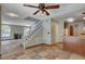 Cozy living room with a fireplace, staircase, and views into the kitchen at 9655 Lame Horse Dr, Las Vegas, NV 89123