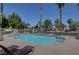 Community pool featuring mature palms and lounge seating with a fenced perimeter at 9655 Lame Horse Dr, Las Vegas, NV 89123