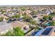 Wide aerial view showcases homes equipped with solar panels, nestled amongst green trees, with pool and patio at 9831 Running Rabbit St, Las Vegas, NV 89143